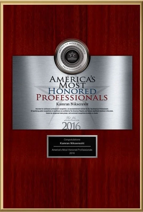 The image displays a framed award with text that reads  AMERICA S MOST HONORED PROFESSIONALS 2016  and features the name  Roman Mikolajewski.  It is presented on a wooden surface.